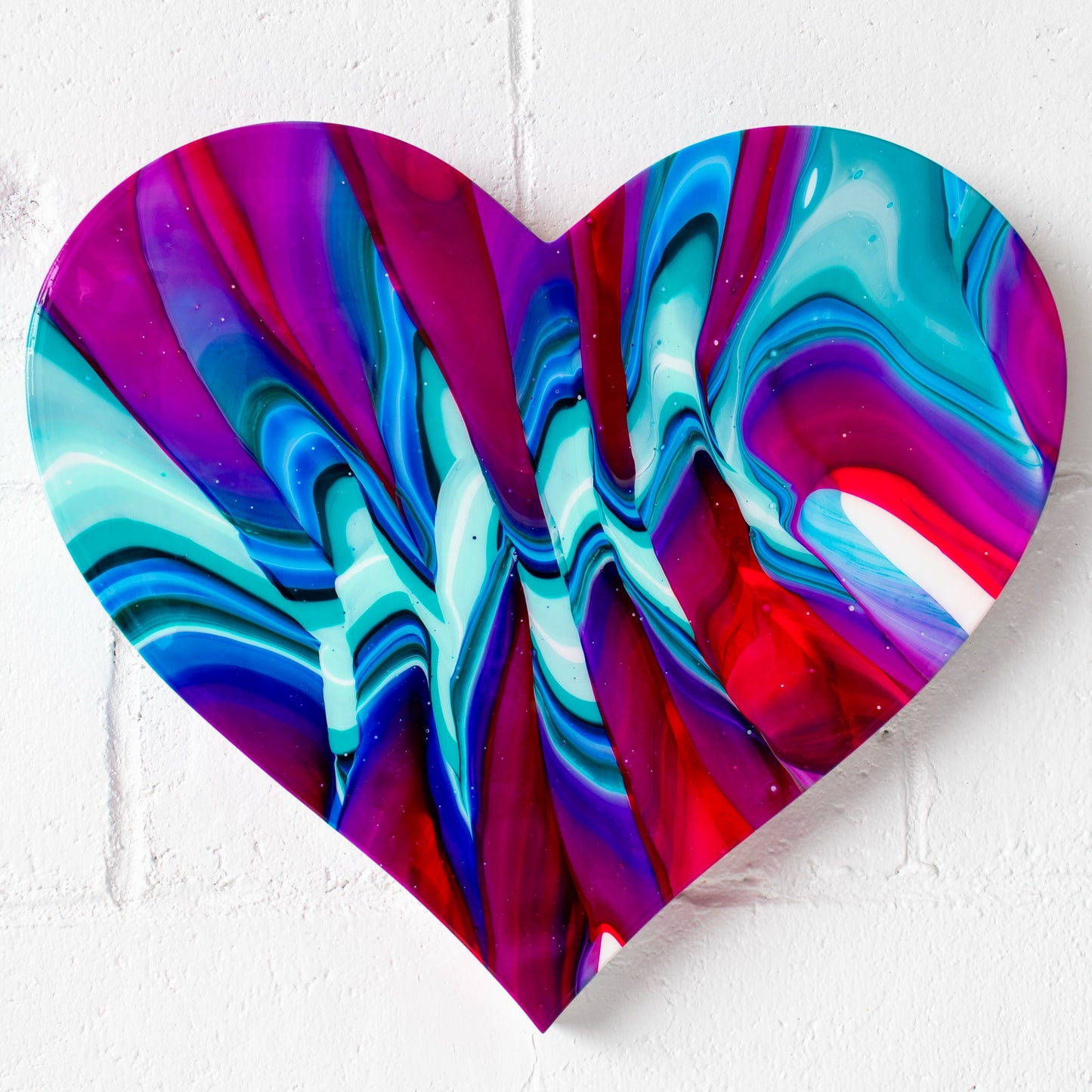 Eternal Love, (20.5” X18”) by abstract artist Callen Schaub, features vibrant multicolored zigzags across a resined, heart canvas. This abstract work is the 14th painting in the artist's After Life Collection.